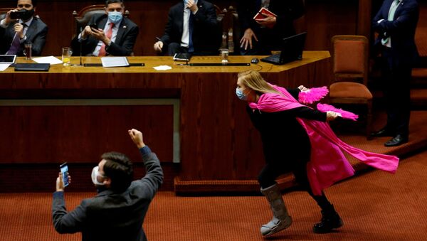 Şili’de acil koronavirüs yardımını öngören yasa tasarısının parlamentoda kabul edilmesi karşısında aşırı coşkuya kapılan milletvekili Pamela Jiles, pembe pelerin ve yelpazelerle yaptığı ‘sevinç turu’ sosyal medyanın gündemine yerleşti. - Sputnik Türkiye