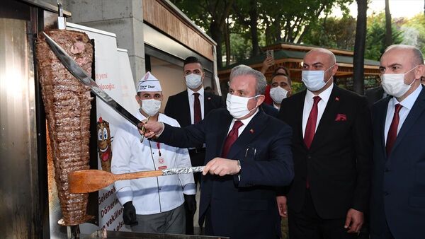 Şentop, kendisine hediye edilen bir kılıçla döner keserek misafirlere ikramda bulundu. - Sputnik Türkiye