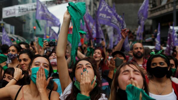 Arjantinli kadın hakları savunucuları, kürtaj yanlılarının simgesi yeşil eşarplar eşliğinde Kongre önünde kamp kurup gövde gösterisi yaptı. Serbest ve Güvenli Yasal Kürtaj Hakkı İçin Ulusal Kampanya destekçisi binlerce kadın, Meclis'teki tartışma ve oylamayı dev ekranlardan takip edip sonucu gözyaşları içinde birbirlerine sarılarak kutladı. - Sputnik Türkiye