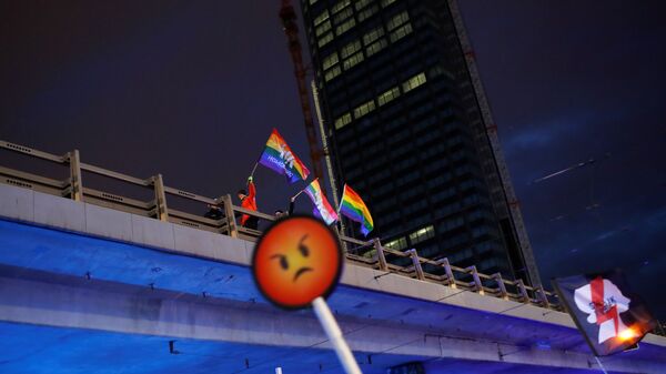 Polonya başkenti Varşova'da 8 Mart Dünya Kadınlar Günü'nde LGBT+ hareketinin simgesi gökkuşağı bayraklarıyla yürüyenler - Sputnik Türkiye