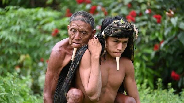 Brezilya'daki Amazon yağmur ormanlarında 24 yaşındaki Tawy'nin 67 yaşındaki babası Wahu'yu sırtına alıp 6 saat yürüyerek aşı merkezine ulaştığından, Dr. Erik Jennings Simões'in çektiği fotoğraf sayesinde dünyanın haberi oldu.  - Sputnik Türkiye