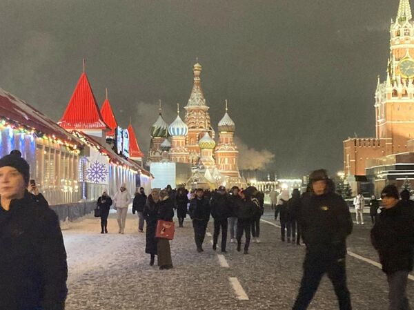 Kremlin Sarayı ve Kızıl Meydan beyaza bürünürken, bu anlara tanıklık etmek isteyen yerli ve yabancı turistler Kızıl Meydan’a akın etti. - Sputnik Türkiye