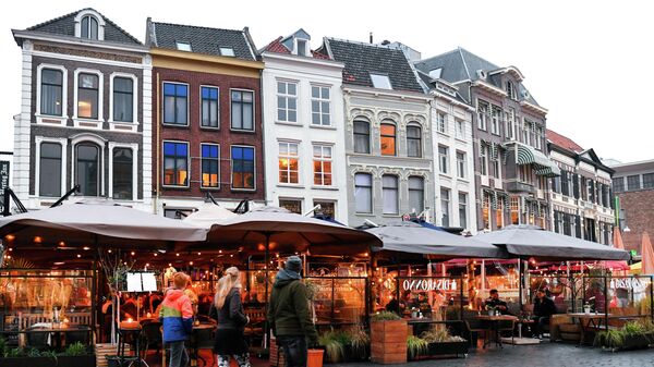 Hollanda'nın Nijmegen şehrinde bir sokakta restoran ve barların önünden geçenler - Sputnik Türkiye