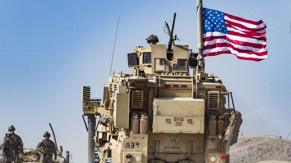 A US soldier sits atop an armoured vehicle - ABD - asker - Sputnik Türkiye