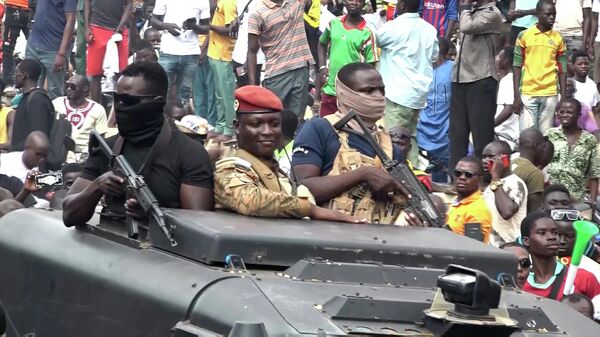 Burkina Faso'da yönetime el koyan yüzbaşı İbrahim Traore askeri araçla başkent Vagadugu'da kendisine sevgi gösterisi yapan taraftarlarının arasından geçerken - Sputnik Türkiye