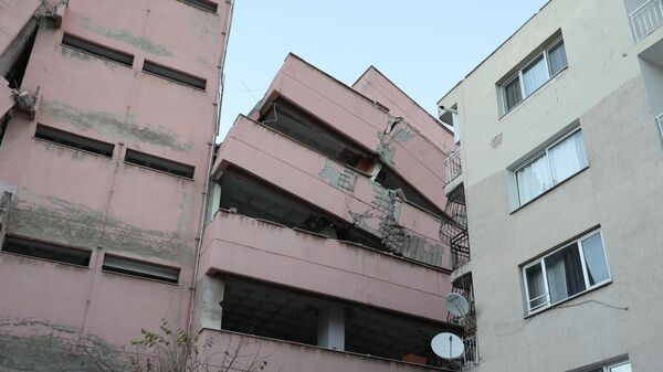 İzmir'in Karabağlar ilçesinde depreme dayanıksız olduğu gerekçesiyle boşaltılan 6 katlı lise binası, yıkım esnasında yan yattı - Sputnik Türkiye