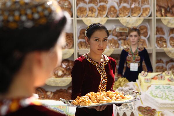 Aşkabat'taki Sergi ve Fuar Merkezi'nde Türkmenistan'ın bağımsızlığının ilan edilmesinin 19. yılı münasebetiyle düzenlenen Ekonomik Başarılar Sergisi'nde misafirleri karşılayan Türkmen kızları - Sputnik Türkiye