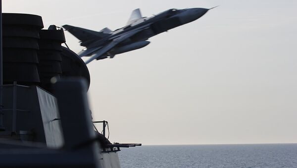 An undated US Navy picture shows what appears to be a Russian Sukhoi SU-24 attack aircraft making a very low pass close to the U.S. guided missile destroyer USS Donald Cook in the Baltic Sea. - Sputnik Türkiye