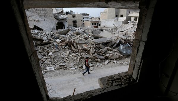 Suriye'nin İdlib kentinde bir adam, 'muhaliflerin' kontrolündeki bölgede yürüyor. - Sputnik Türkiye