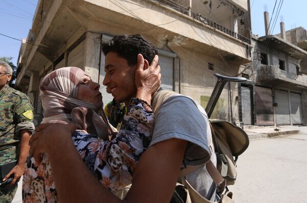 Kente giren Demokratik Suriye Güçleri askerini öpen Menbiçli bir teyze. - Sputnik Türkiye