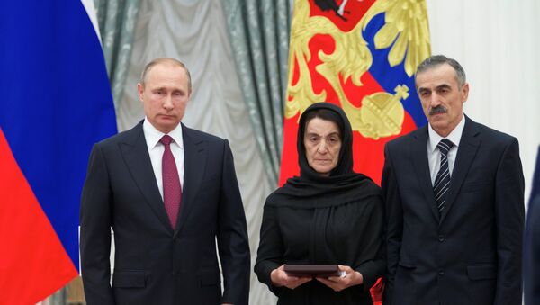 Kremlin Sarayı’nda düzenlenen törende Rusya Devlet Başkanı Vladimir Putin, kahramanın Kızıl Yıldız madalyasını polisin babası ve annesine teslim etti. - Sputnik Türkiye