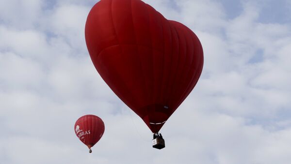 A heart-shaped hot air balloon (R) flies in the sky during the Love Cup 2016 event, ahead of Valentine's Day, in Jekabpils, Latvia, February 13, 2016 - Sputnik Türkiye
