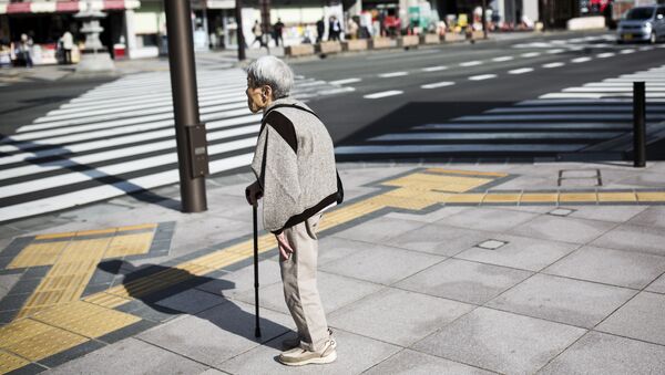 A Japanese elderly woman waits for the traffic light to cross the street in Nagano, northwest of the capital Tokyo on November 7, 2016 - Sputnik Türkiye
