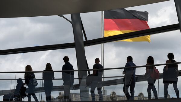 Visitors walk in the glass cupola of the Reichstag building that hosts the German parliament (Bundestag) and look at a German flag in Berlin, Germany, on June 10, 2016. - Sputnik Türkiye