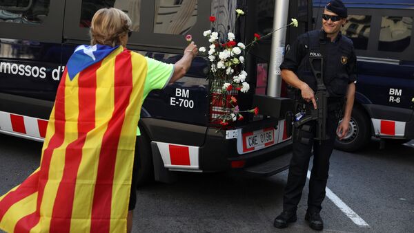 Kataln bayrağı Estalada'yı kuşanan bir bağımsızlık yanlısı İspanyol jandarmasının aracına çiçek bırakıyor - Sputnik Türkiye