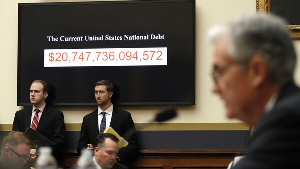 The National debt is shown behind Federal Reserve Chairman Jerome Powell as he testifies on the semiannual monetary policy report to the House Financial Services Committee, Tuesday, Feb. 27, 2018, in Washington - Sputnik Türkiye
