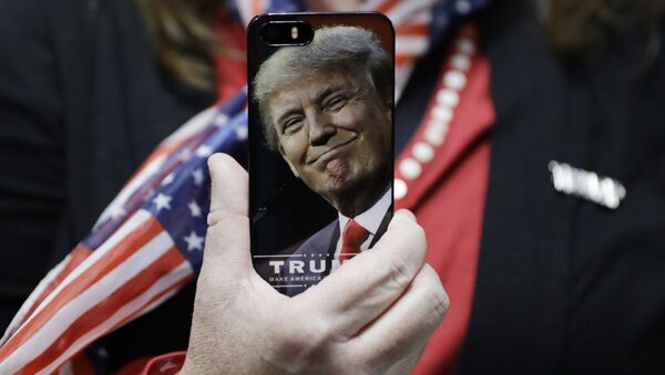 In this Thursday, Sept. 29, 2016, file photo, a woman holds up her cell phone before a rally with then presidential candidate Donald Trump in Bedford, N.H. - Sputnik Türkiye