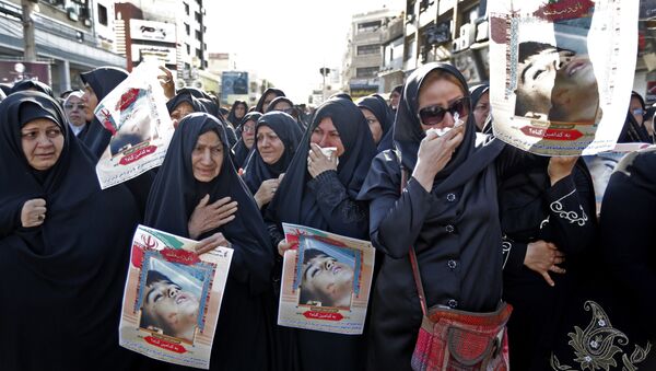 Ahvaz'daki cenaze töreninde Devrim Muhafızları kendi mensuplarının tabutlarını ve fotoğraflarını taşırken gözüyaşlı kadınlar da saldırının 4 yaşındaki kurbanı Muhammad Taha Eghdami'nin fotoğrafını açtı. - Sputnik Türkiye