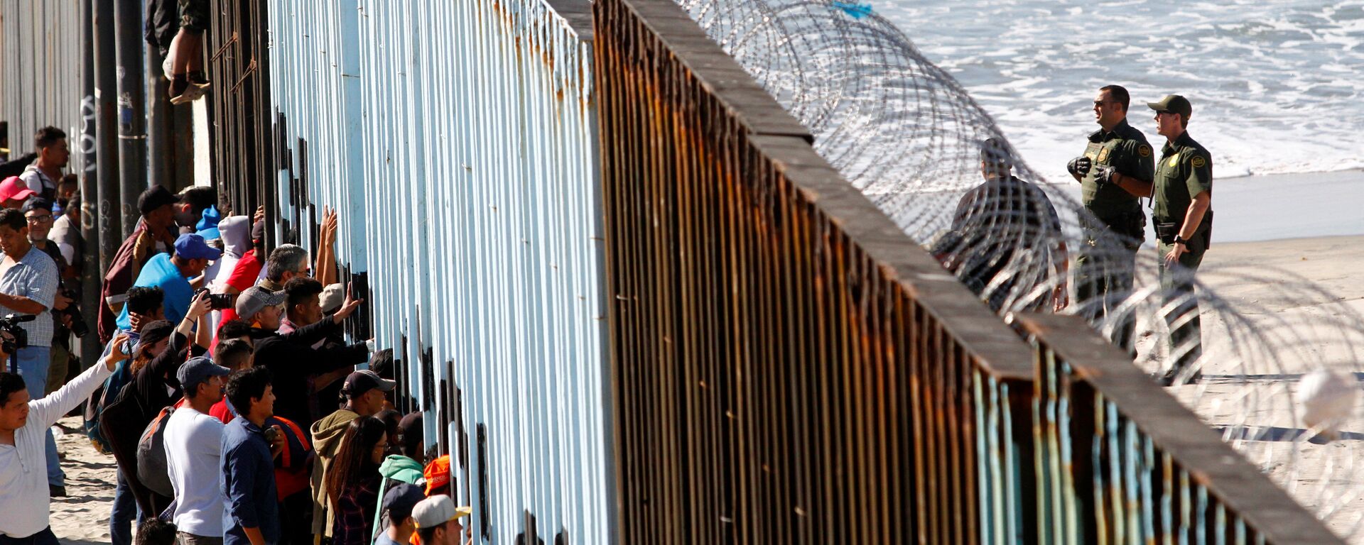 Orta Amerikalı göçmen kervanından 800-1000 kişilik bir grup, Meksika'nın ABD sınırındaki Tijuana'ya ulaştı. Göçmenler, kentte ABD ile sınırı belirleyen duvarı adeta kuşatmaya aldı. - Sputnik Türkiye, 1920, 05.08.2021