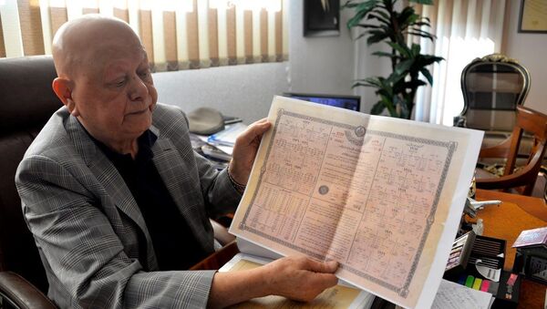 Babasına ait sandıktan, dedesinin babasına ait olduğu düşünülen 1917 yılına ait tahvil çıktığını söyleyen Antalya'da 79 yaşındaki turizmci Akay Okudur - Sputnik Türkiye