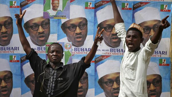 Supporters of presidential candidate Muhammadu Buhari gesture in front of his election posters in Kano - Sputnik Türkiye