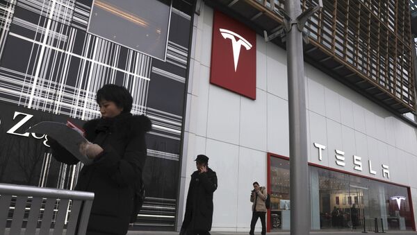 Residents walk past a Tesla store in Beijing - Sputnik Türkiye