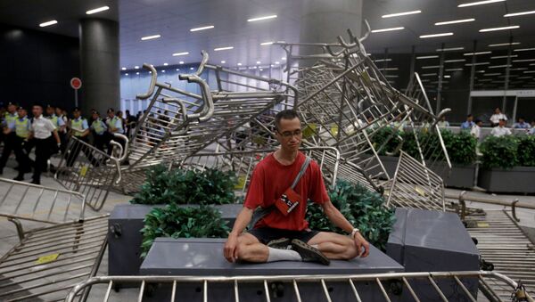 Hong Kong'da yasal konsey önünde çatışmalar yaşanırken protestoculardan biri meditasyon yapma yoluna gitti. - Sputnik Türkiye