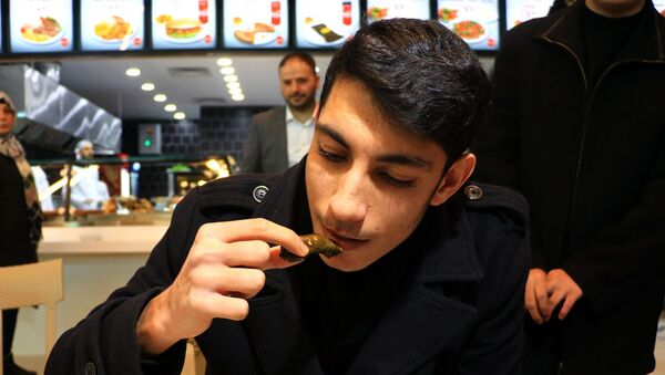 Adana’da bir ev yemekçisinin açılışında düzenlenen yaprak sarma yeme yarışması renkli görüntüler oluşturdu. 1 dakikada 20 yaprak sarmasını bitiren genç, yarım altının sahibi oldu. - Sputnik Türkiye