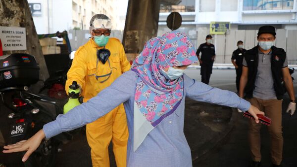 Koronavirüs önlemleri çerçevesinde sokakta dezenfekte edilen bir kadın, Kuala Lumpur, Malezya - Sputnik Türkiye