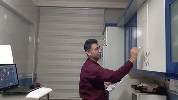 Kayseri'de, 45 yaşındaki matematik öğretmeni Mustafa Gürel, mutfak dolabını yazı tahtası gibi kullanarak internet üzerinden öğrencilerine ders anlattı. - Sputnik Türkiye