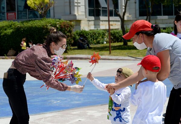 Muratpaşa Belediyesi, 4 saatliğine sokağa çıkma izni verilen çocukları, Muratpaşa Atatürk Kent Meydanı’nda rüzgar gülleriyle karşıladı. - Sputnik Türkiye