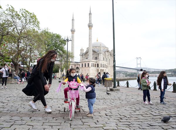 İstanbul'da yeni tip koronavirüs (Kovid-19) nedeniyle sokağa çıkmaları kısıtlanan 14 yaş altı çocuklar, 11.00-15.00 saatlerinde getirilen serbestlik ile uzun bir aradan sonra dışarı çıktı. Ortaköy'e aileleriyle gelen çocuklar oyun oynadı. - Sputnik Türkiye